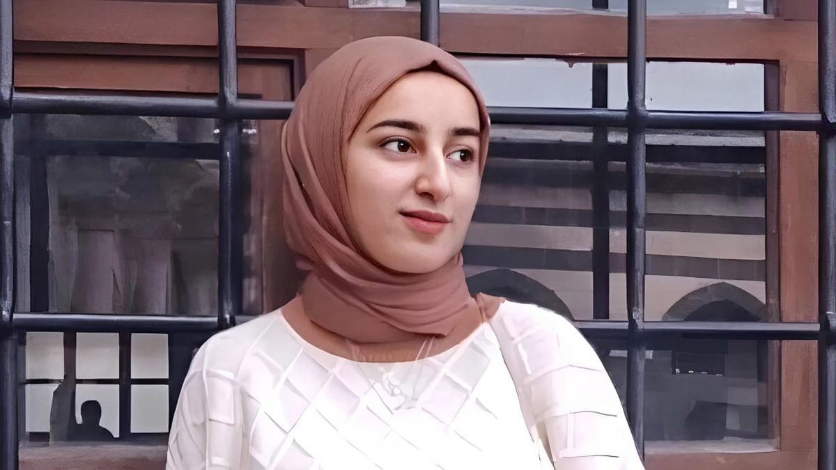 Başörtülü genç kadın, tarihi taş bina önünde düşünceli poz veriyor – kültürel portre fotoğrafı #gazetegezegen